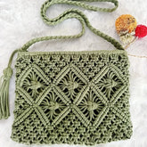 Green macrame handbag with a tassel on a white background