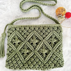 Green macrame handbag with a tassel on a white background