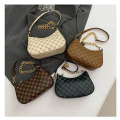 Four patterned handbags with gold chains on a gray and white surface