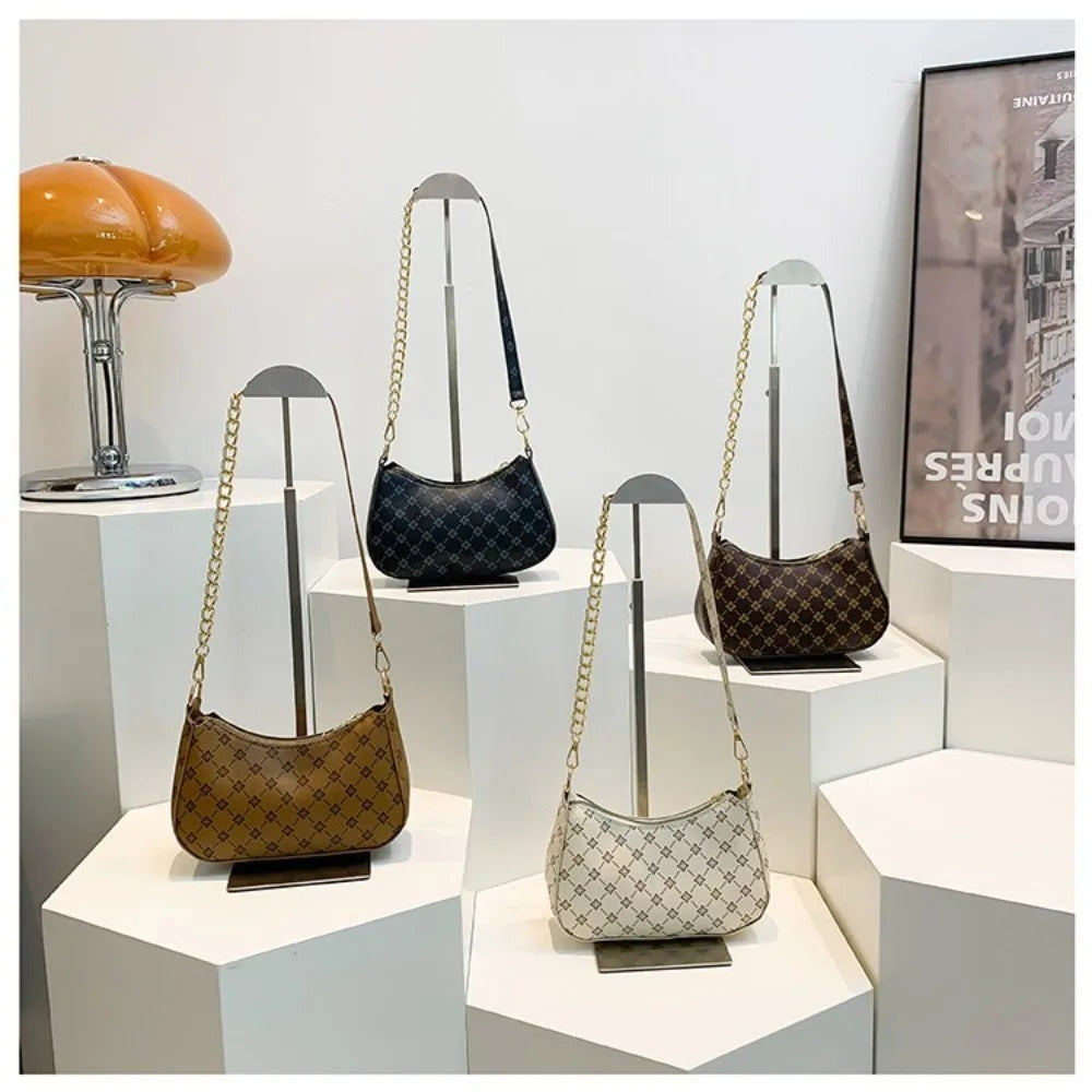 Four handbags displayed on a white surface with a neutral background