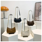 Four handbags displayed on a white surface with a neutral background