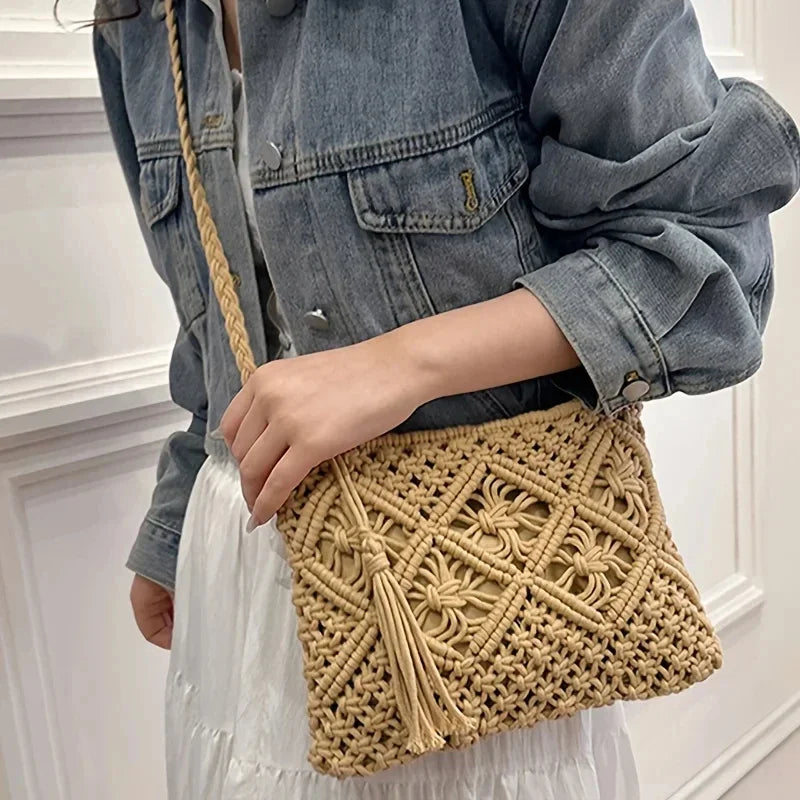 Person holding a beige woven handbag with a denim jacket and white dress.