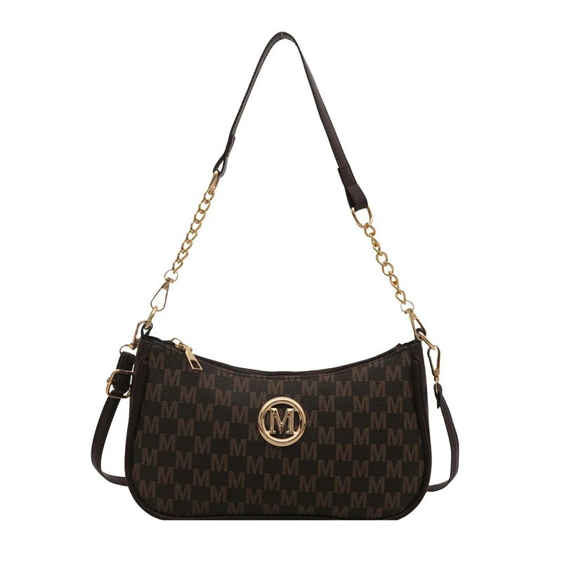 Black handbag with gold chain strap and logo on a white background