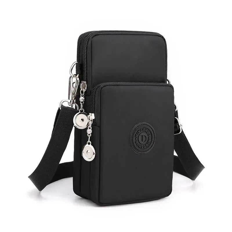 Black crossbody bag with a strap and decorative elements on a white background