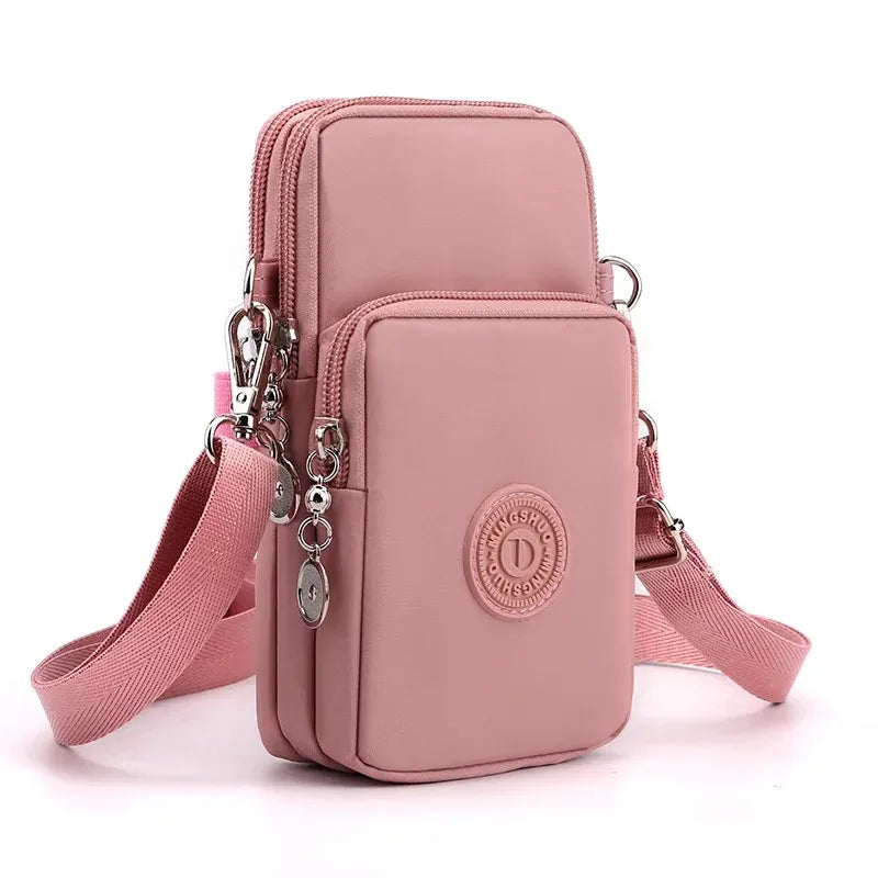 Pink crossbody bag with multiple pockets and a visible brand logo on a white background