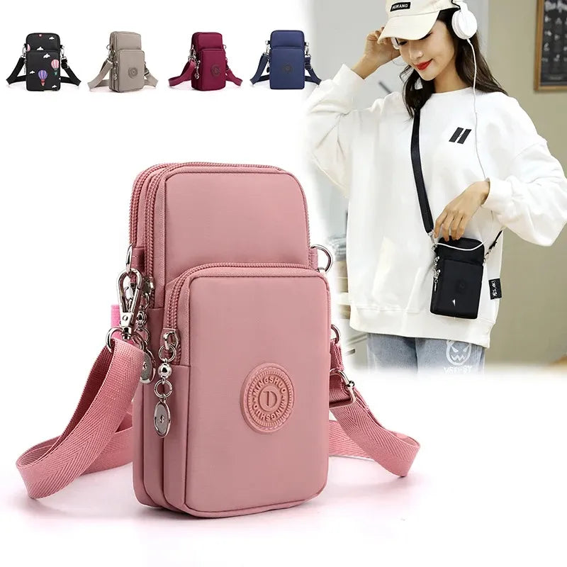 Pink crossbody bag with multiple pockets and a strap, displayed with a person wearing headphones in the background.