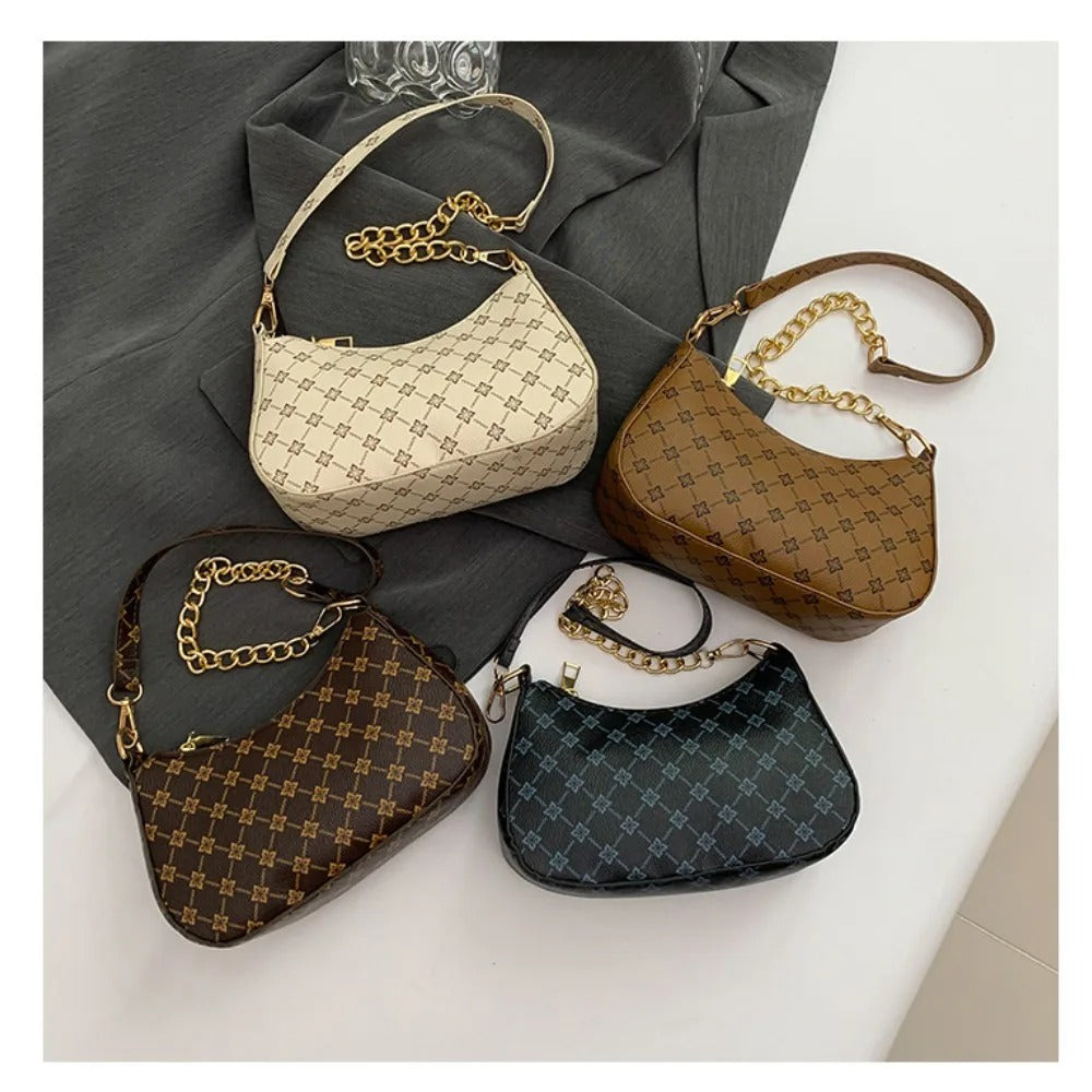 Four patterned handbags with gold chains on a gray and white surface