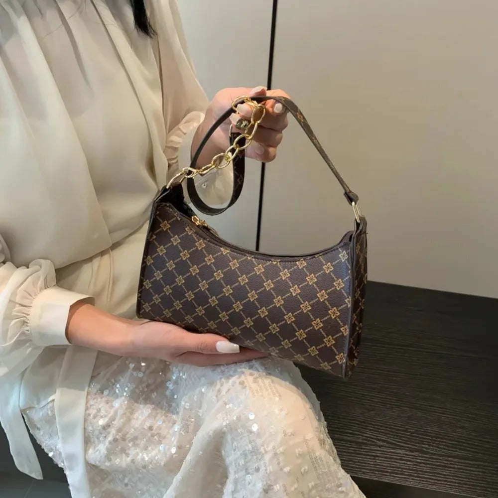 Person holding a patterned handbag with a neutral background