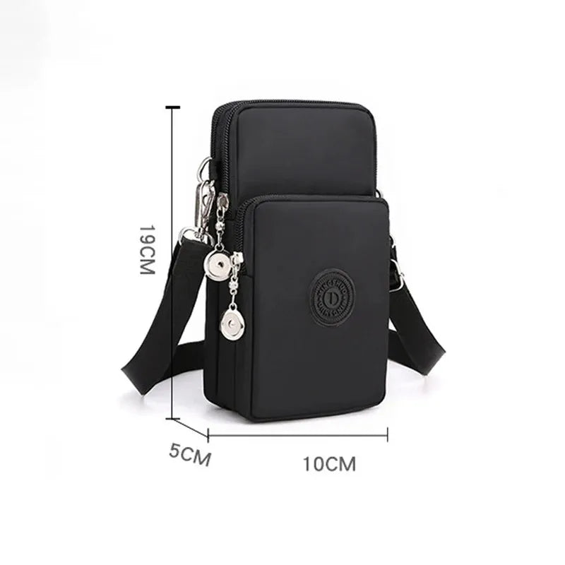 Black nylon crossbody phone bag with a front zip pocket, shown with dimension markings of 19cm height, 10cm width, and 5cm depth on a white background.