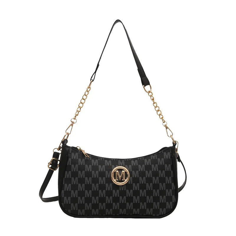 Black handbag with gold chain strap and logo on a white background