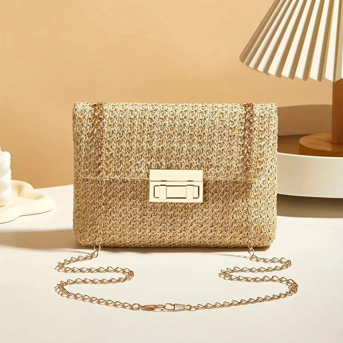 Woven handbag with a chain strap on a light surface with a neutral background